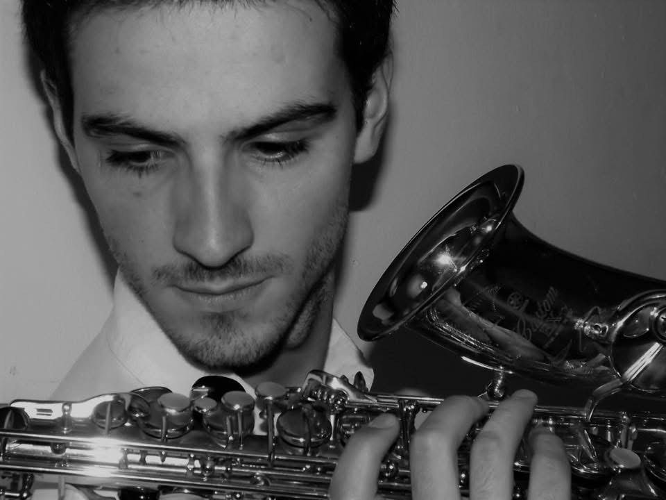Black and white portrait of a person holding a saxophone, looking downwards.